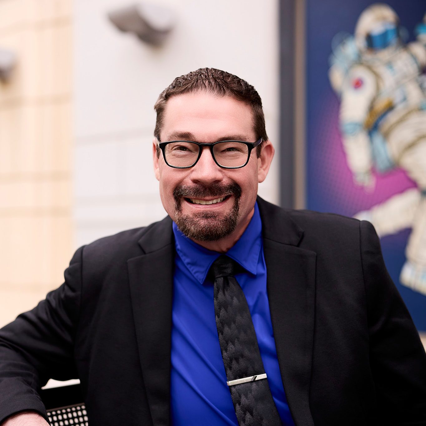 smiling man wearing a blue dress shirt and suit